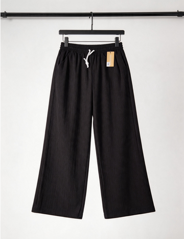 Black pants on a hanger with a white background