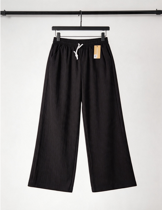 Black pants on a hanger with a white background