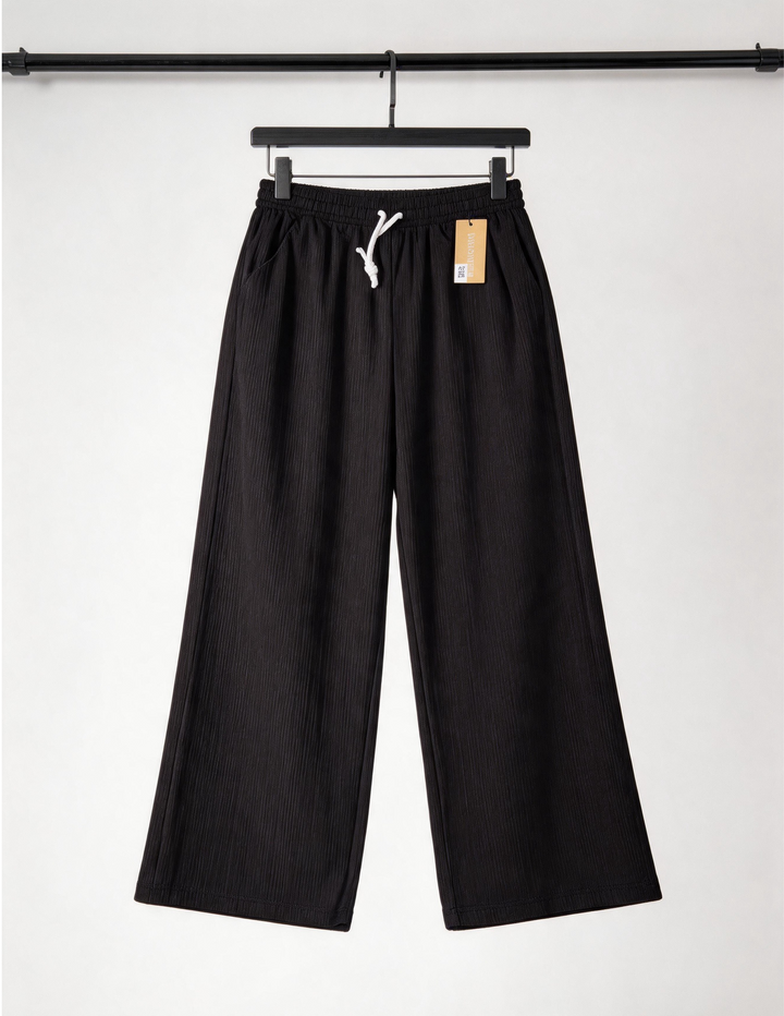 Black pants on a hanger with a white background