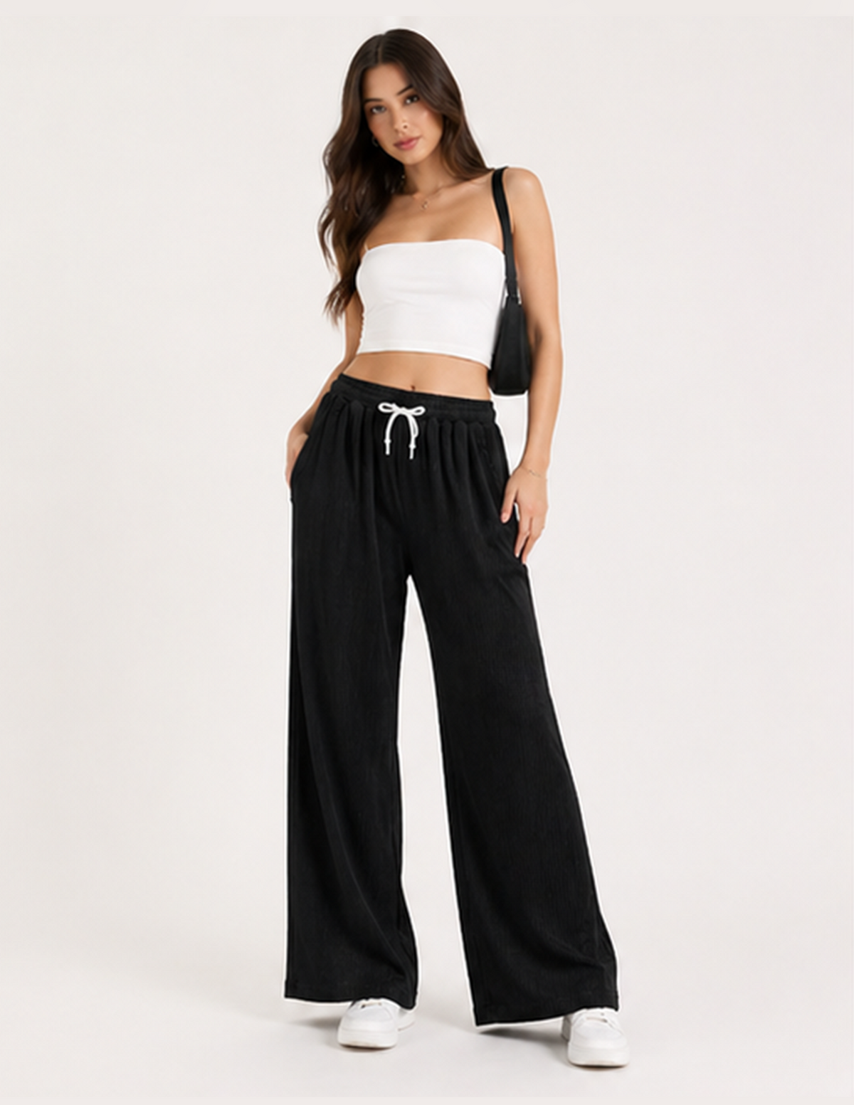 Woman wearing a white top and black wide-leg pants on a white background
