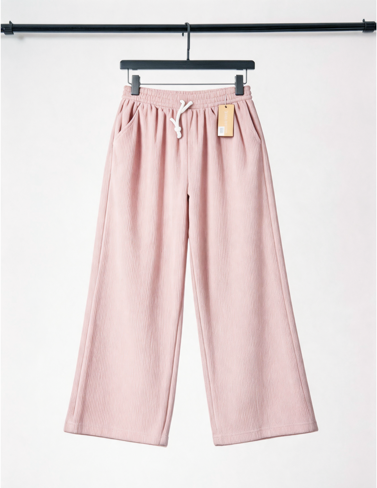 Pink pants on a hanger with a white background