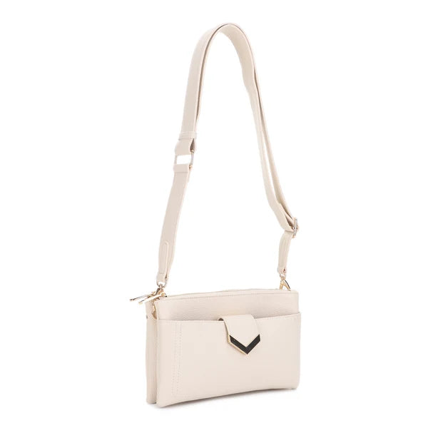 A light cream-colored faux leather crossbody bag with a matching adjustable shoulder strap, a front zippered pocket, and a small black chevron accent on the front flap.